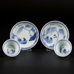 Een set van (2) porseleinen kop en schotels met decor figuren in een landschap. China, Kangxi.