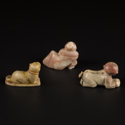 Een lot van (3) spekstenen beeldjes in de vorm van een kruipend en zittend mannetje en een liggende hond. Azië, 19e eeuw.