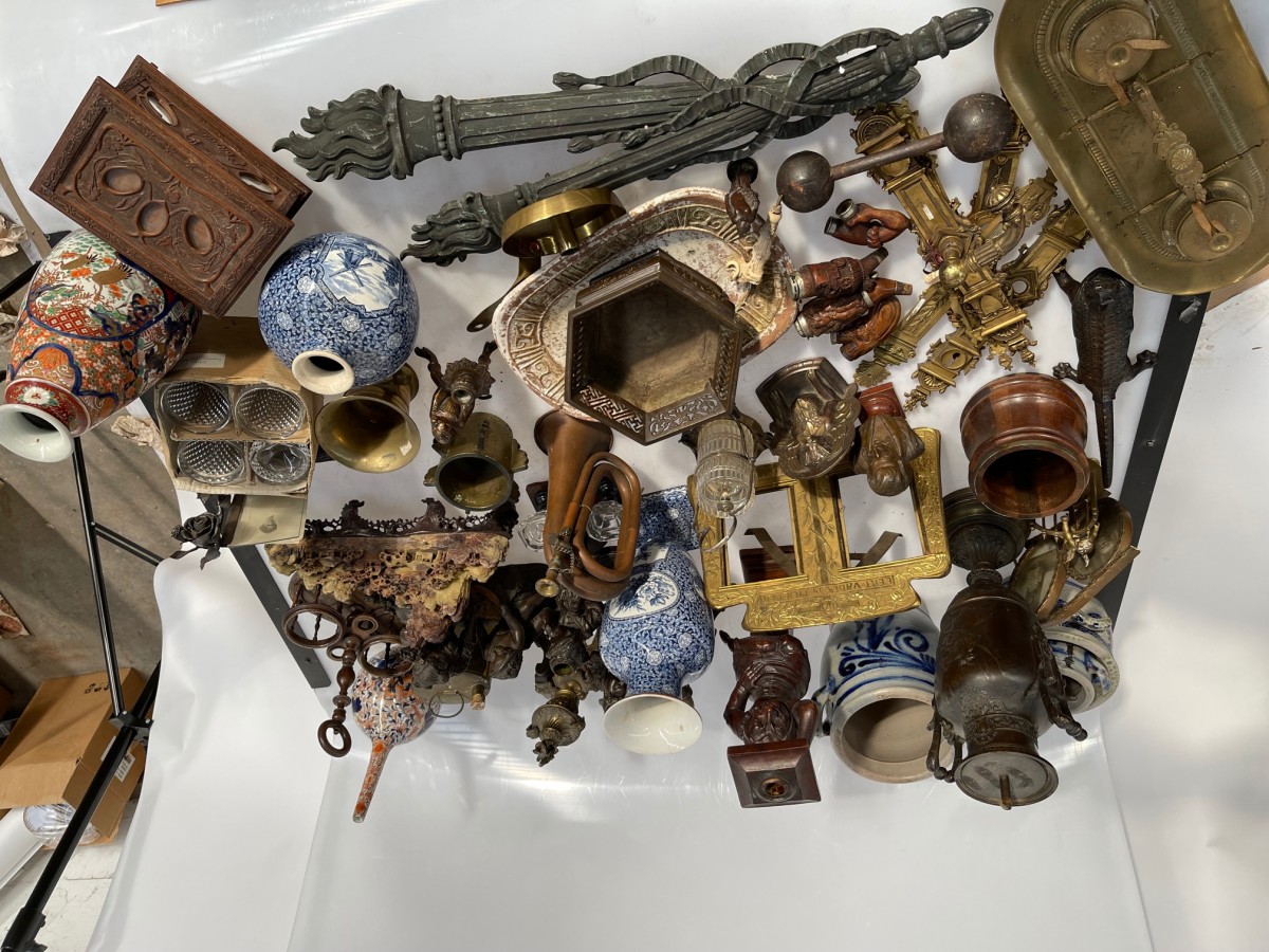 Een lot bestaande uit wandornamenten, messing deurbeslag, een koperen inktstel, een kandelaar in de vorm van een lachende figuur, Keulse potten, fotolijsten en pijpenkoppen.