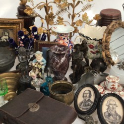 Een lot bestaande uit o.a. een tondelhouder in de vorm van een meisje in klederdracht, twee laat 19e-eeuwse kandelaren met glazen parels, een tasbeugel, twee portretten van Washington en Oliver Cromwell, een tasbeugel, een anemoonvaas en uraniumglas.