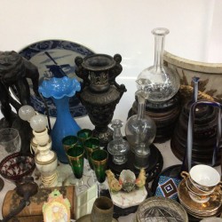 Een groot lot bevattende o.a. een albasten beeld van Athena (beschadigd), een blauw glazen vaasje, een bureau-ornament met bronzen hond, een inktstel en imari.