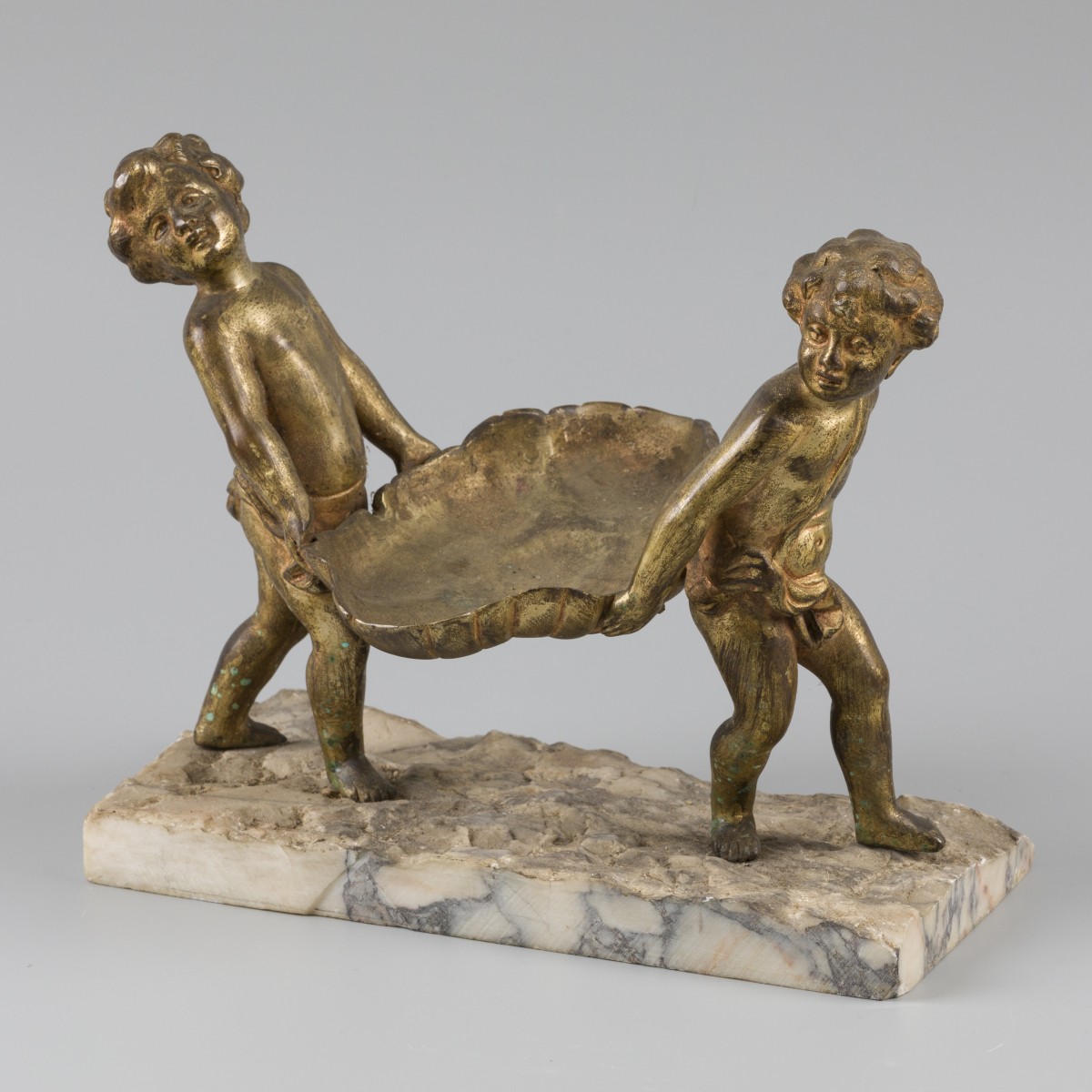 Een bronzen "vide poche" gedragen door putti.