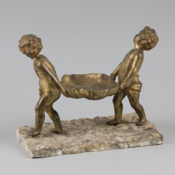 Een bronzen "vide poche" gedragen door putti.