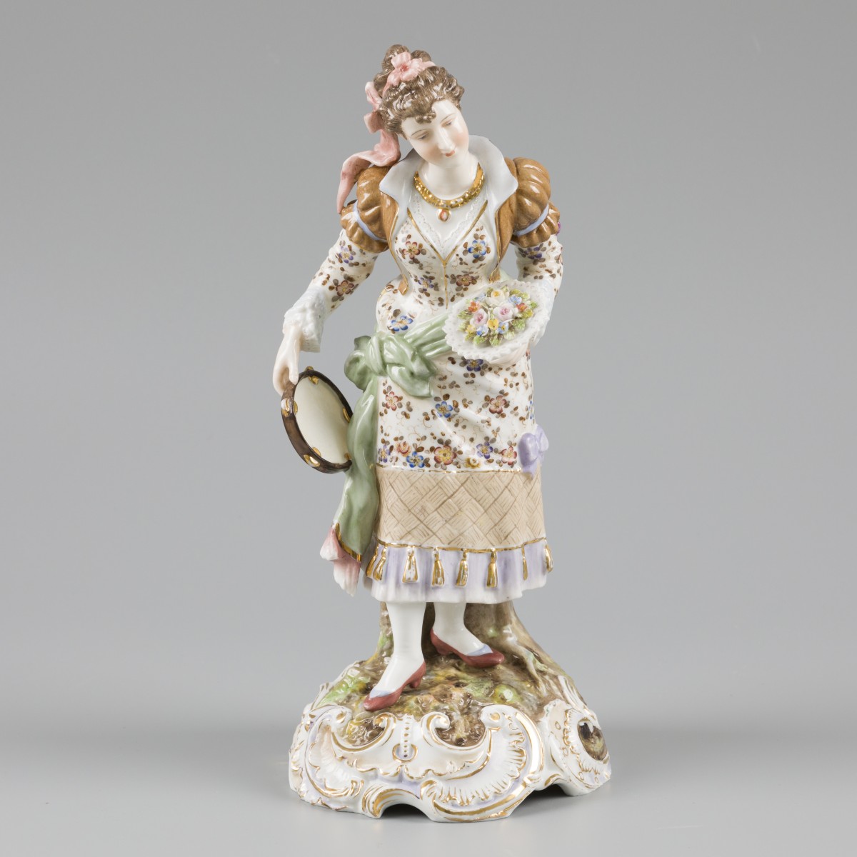 Een porseleinen sculptuur van een dame met in haar handen een boeket en een tamboerijn, gemerkt. Richard Eckert & Co. Volkstedter porseleinfabriek, eind 19e eeuw.