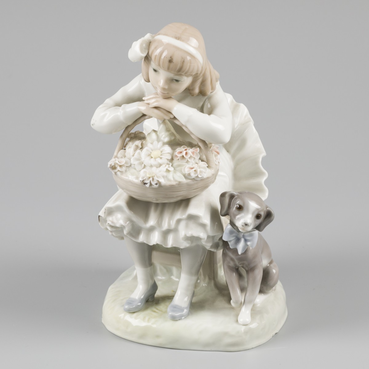 Een Lladro figuurstuk, bloemenmeisje met haar hondje, Spanje, 2e helft 20e eeuw.