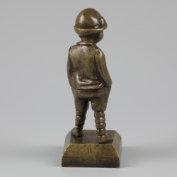 Een bronzen sculptuur van een peuter met de handen in de zakken, België, ca. 1920.