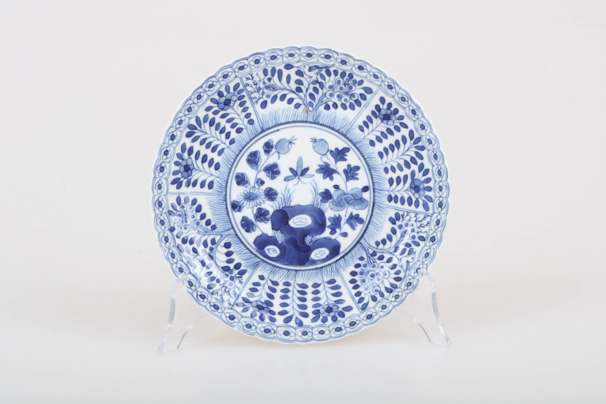 Een porseleinen bord met bloemendecor in vakverdeling, gemerkt gemerkt Kangxi. China, 19e eeuw.