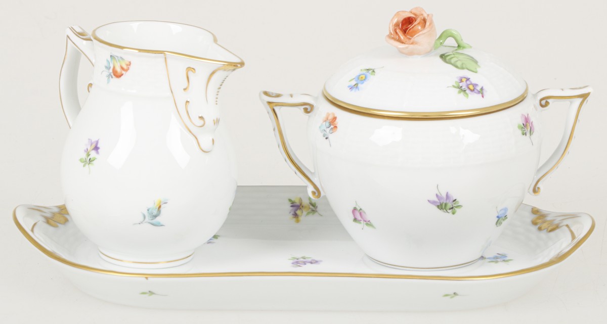 Een roomstel bestaande uit suikerpot, roomkannetje, onderschotel. Decor: 'Gestreute Blume'. Gemerkt a.d. onderzijde: Herend Hungary, handpainted en 635, 665, 437/MF.