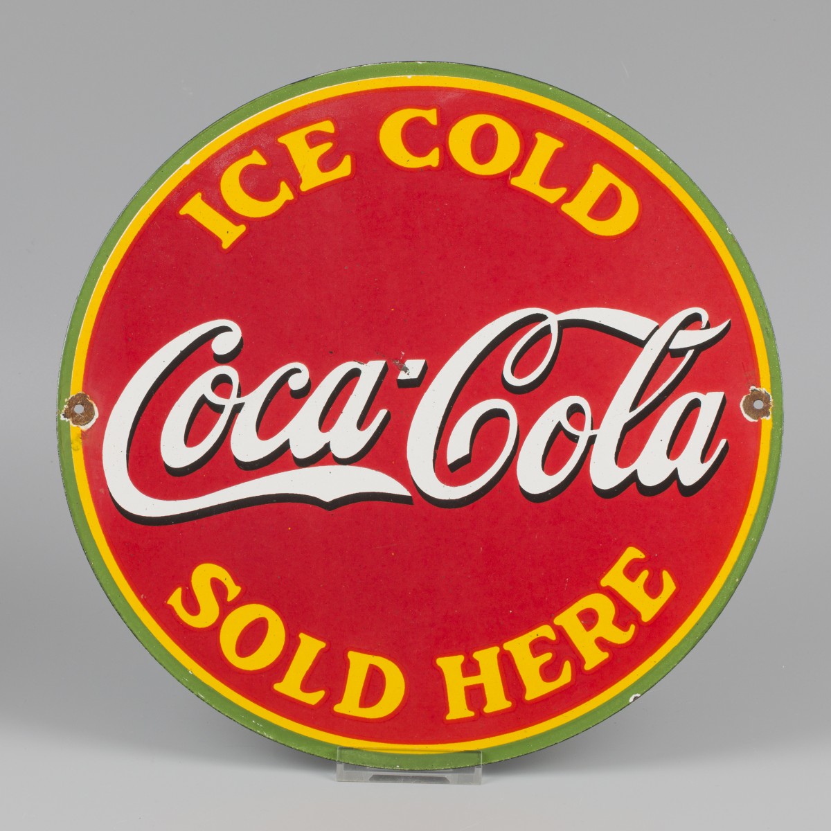 Een emaillen reclamebord met afbeelding van Coca-Cola. Midden 20e eeuw.