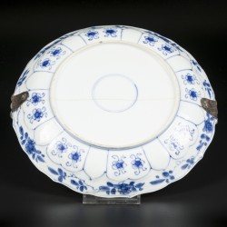 Een porseleinen bord met bladperk decor buitenrand en floraalinterieur Chinees Kangxi met zilveren beugel 19e eeuw.