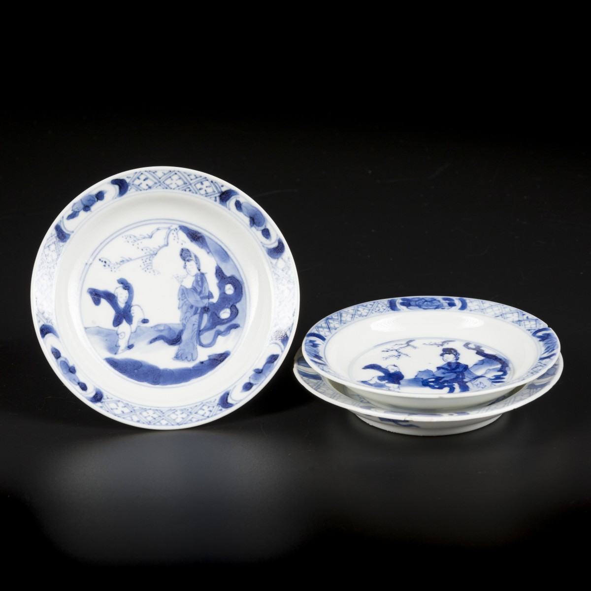 Een lot van (3) Porseleinen schoteltjes met lange lijs en spelend zotje. China, Kangxi 1662-1722.