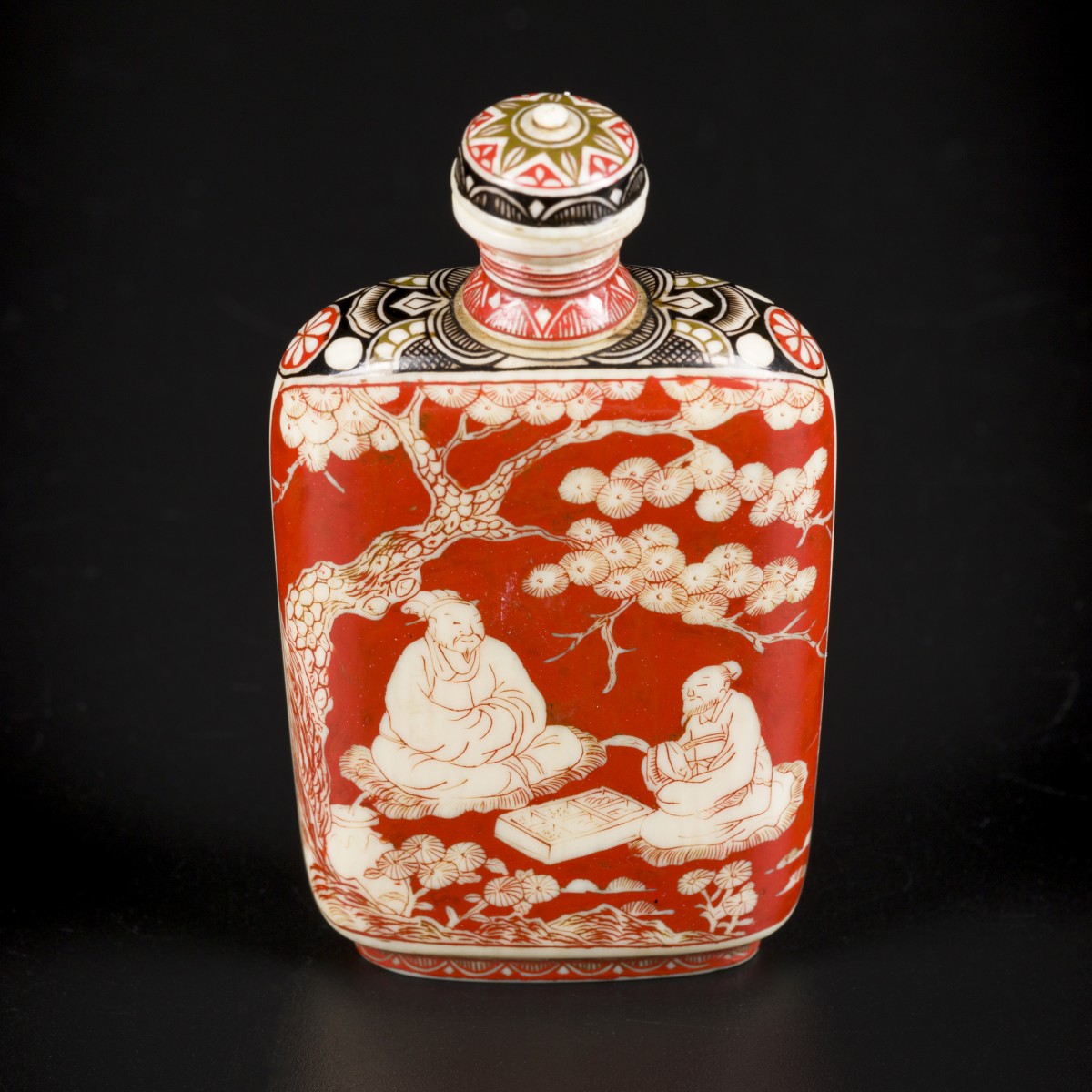 Een ivoren snuff bottle gedecoreerd met diverse figuren onder een bloesemboom. China, eind 19e eeuw.