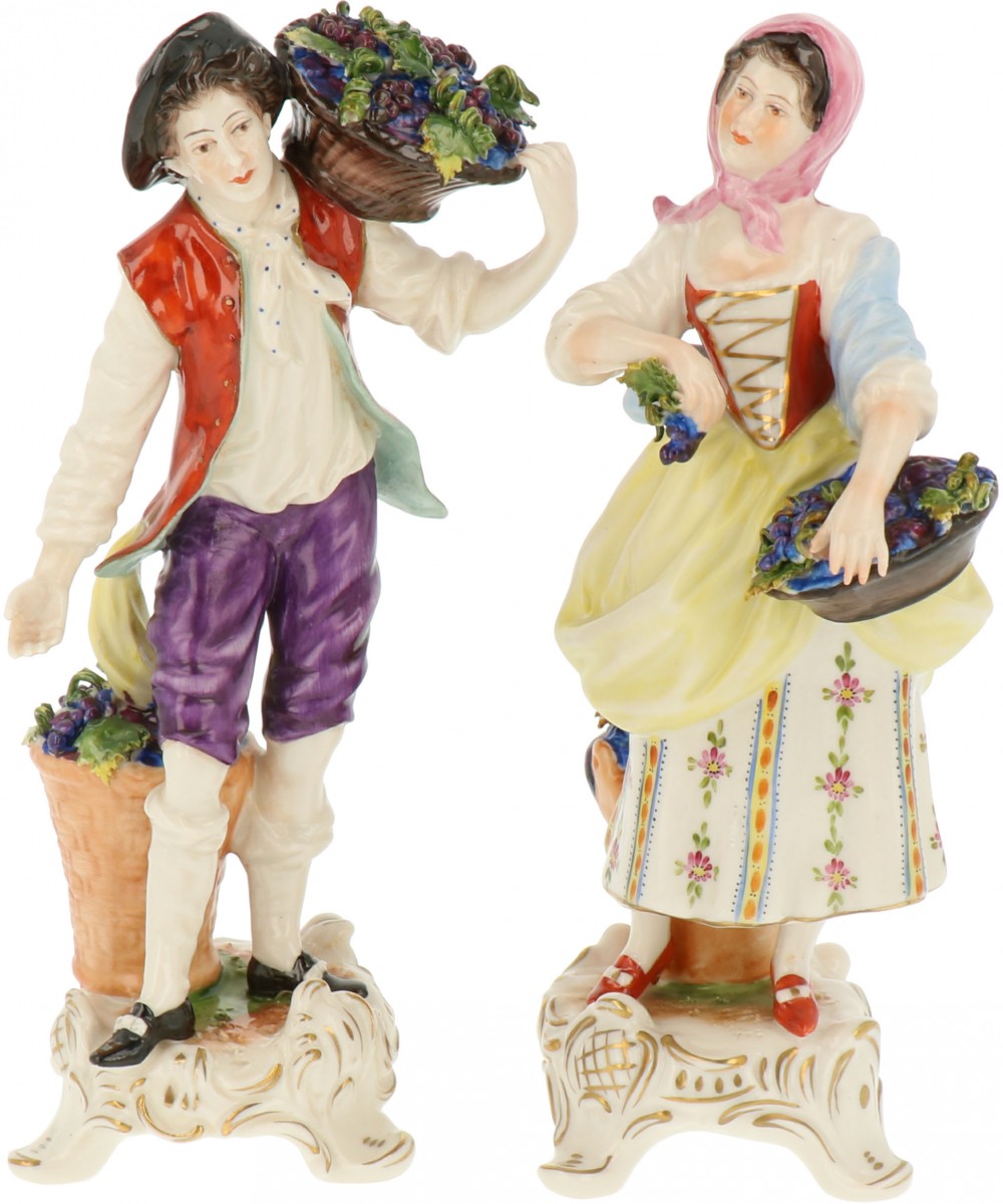 Een stel porseleinen figuren van een wijnboer en boerin. Volkstedt, Duitsland. Midden 20e eeuw.