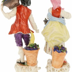 Een stel porseleinen figuren van een wijnboer en boerin. Volkstedt, Duitsland. Midden 20e eeuw.