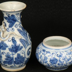 Een lot van (2) bestaande uit een Porseleinen kraagvaasje met draak reliëfdecor en een vaasje, beide floraal decor. China, 19e eeuw.