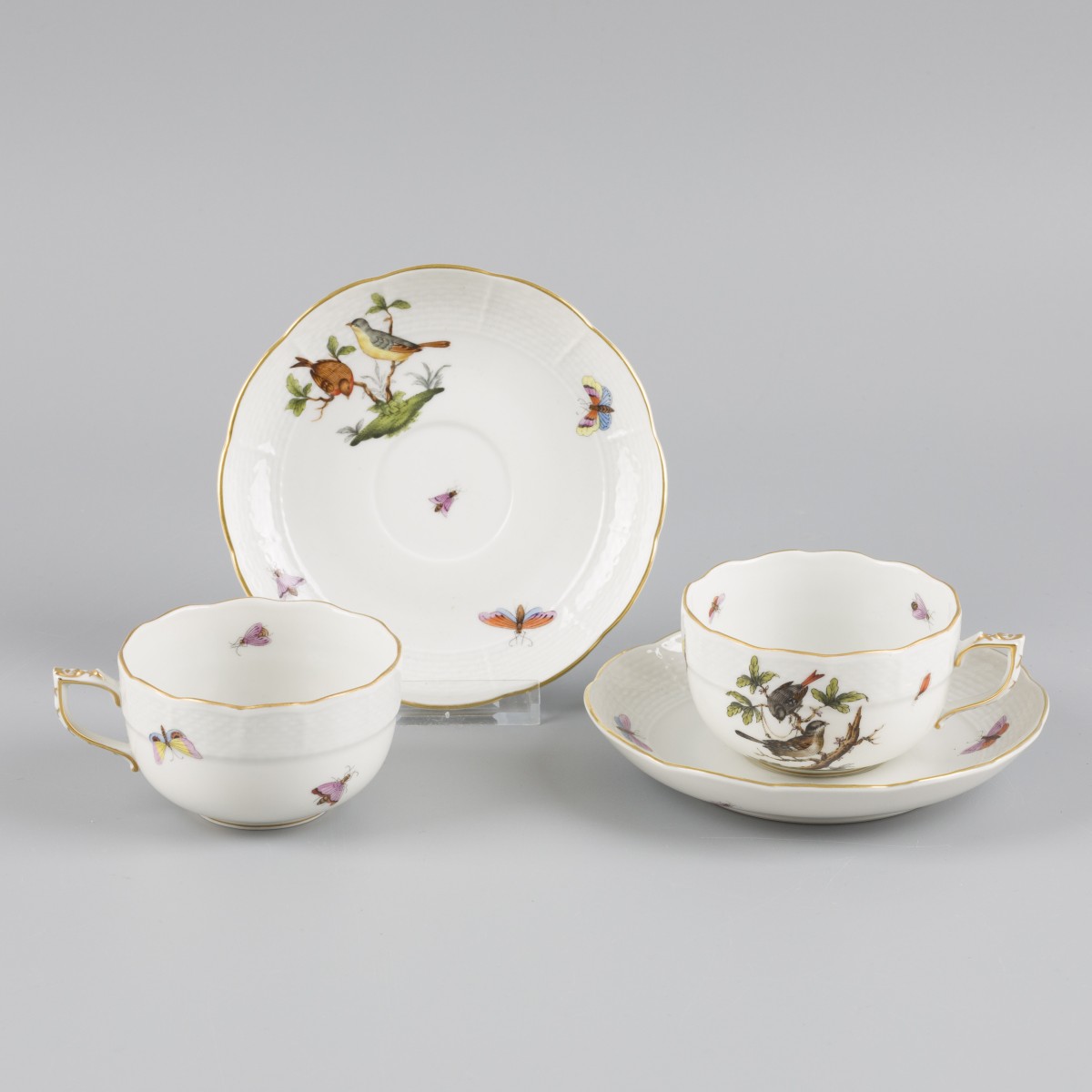 Een set van (2) porseleinen kop-en-schotels met Rotschild Bird decor. Herend, Hongarije, eind 20e eeuw.