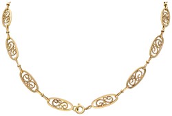 18 kt. Geelgouden art nouveau collier met sierlijke details en navette-vormige schakels.