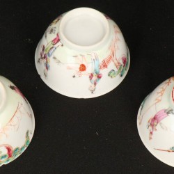 Een set van (3) porseleinen kop en schotels met Famille Rose figuur decoratie. China, eind 18e eeuw.