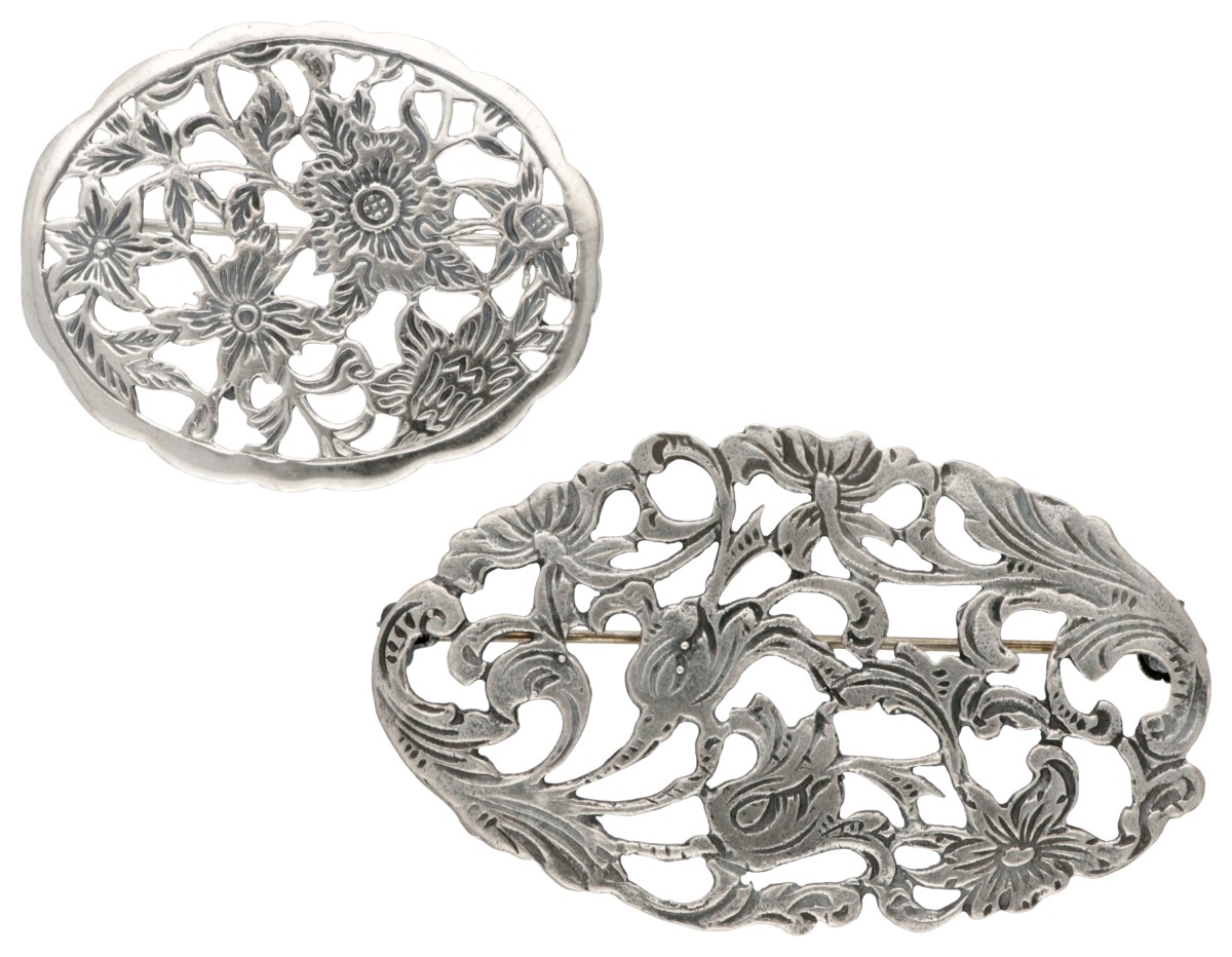 Lot van twee sterling zilveren vintage broches met florale details.