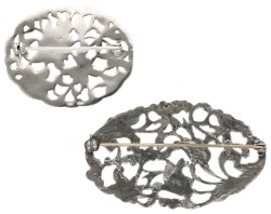 Lot van twee sterling zilveren vintage broches met florale details.