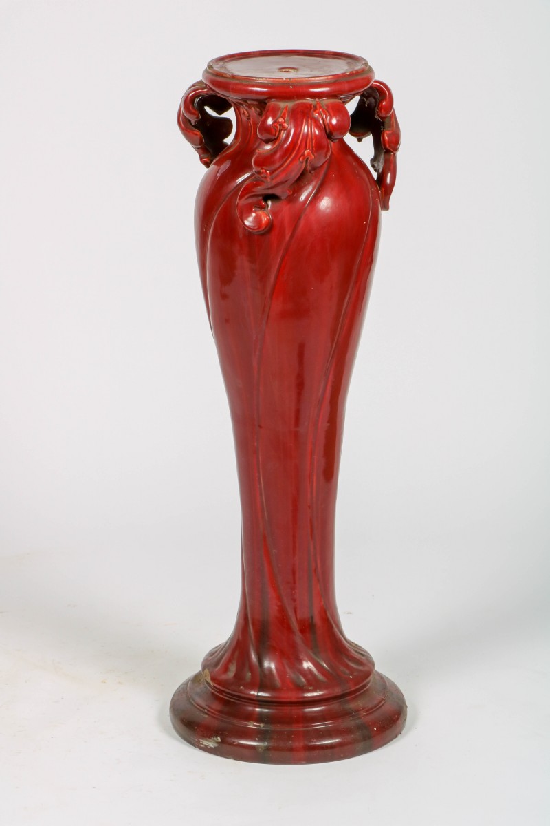 Een Art-Nouveau piëdestal, rood geglazuurd keramiek, ca. 1910.