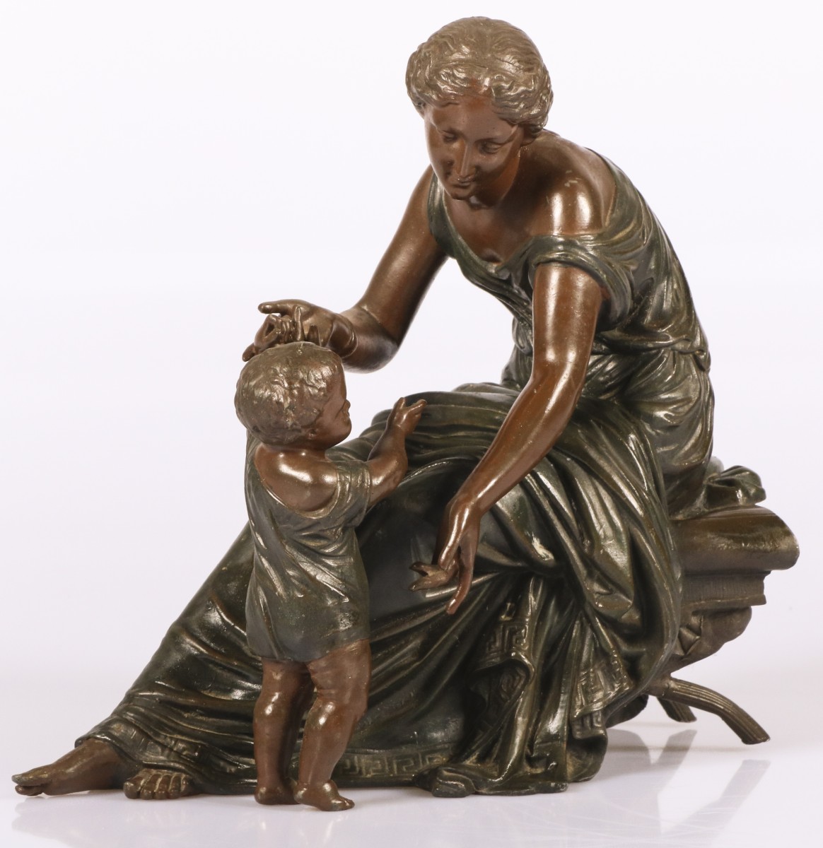 Een Zamac sculptuur van een moeder spelend met haar kind, 20e eeuw.