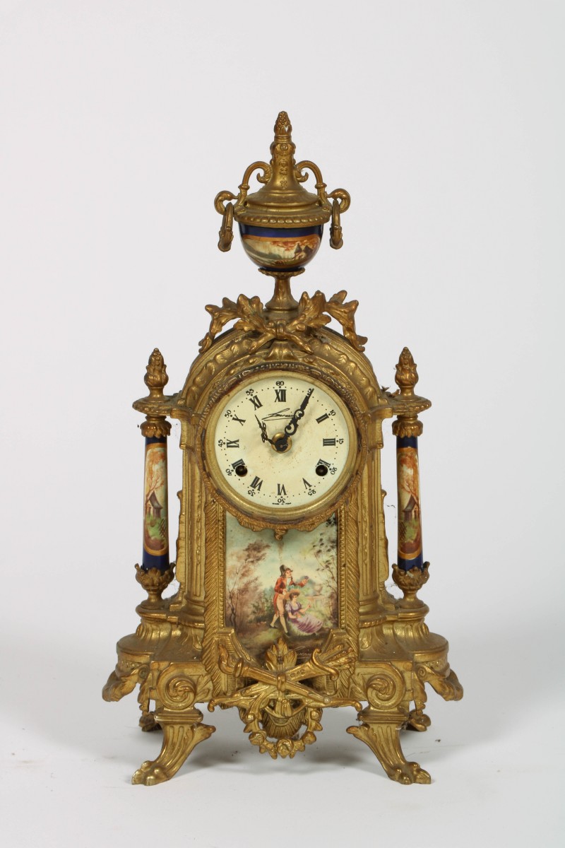 Een verguld bronzen neo-Louis XVI stijl schouwpendule met porseleinen ornamenten, Frankrijk, ca. 1910.