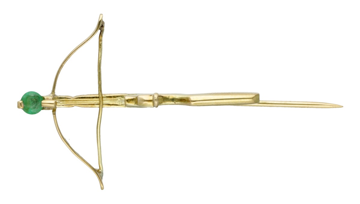 14 kt. Geelgouden hoedenspeld in de vorm van een kruisboogpistool bezet met een smaragd.