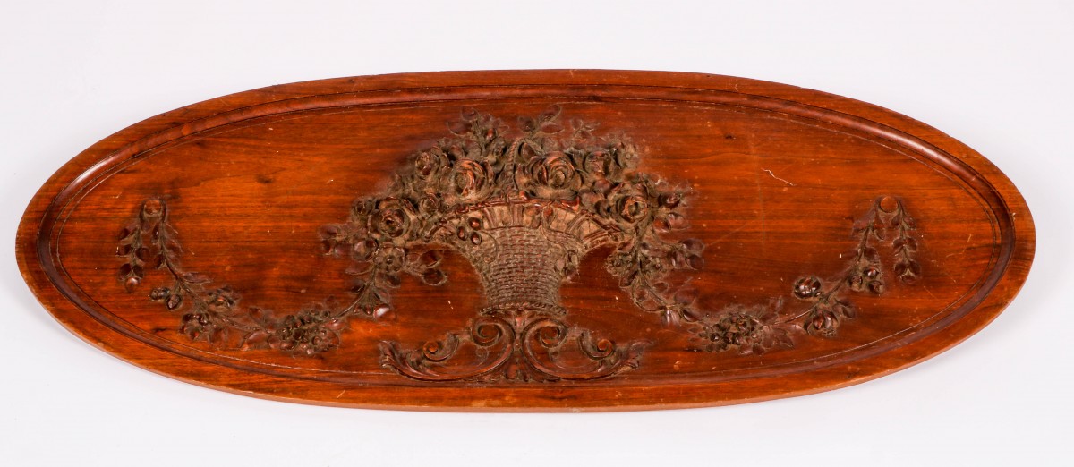 Een ovalen houten reliëf met decor van bloemenurn an guirlandes, vroeg 20e eeuw.