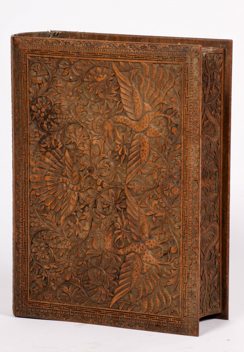 Een rijk gesneden Djati-houten doos in de vorm van een boek, Indonesie, 1e helft 20e eeuw.