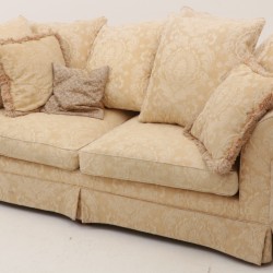 Een sofa met diepe zit en kussens.