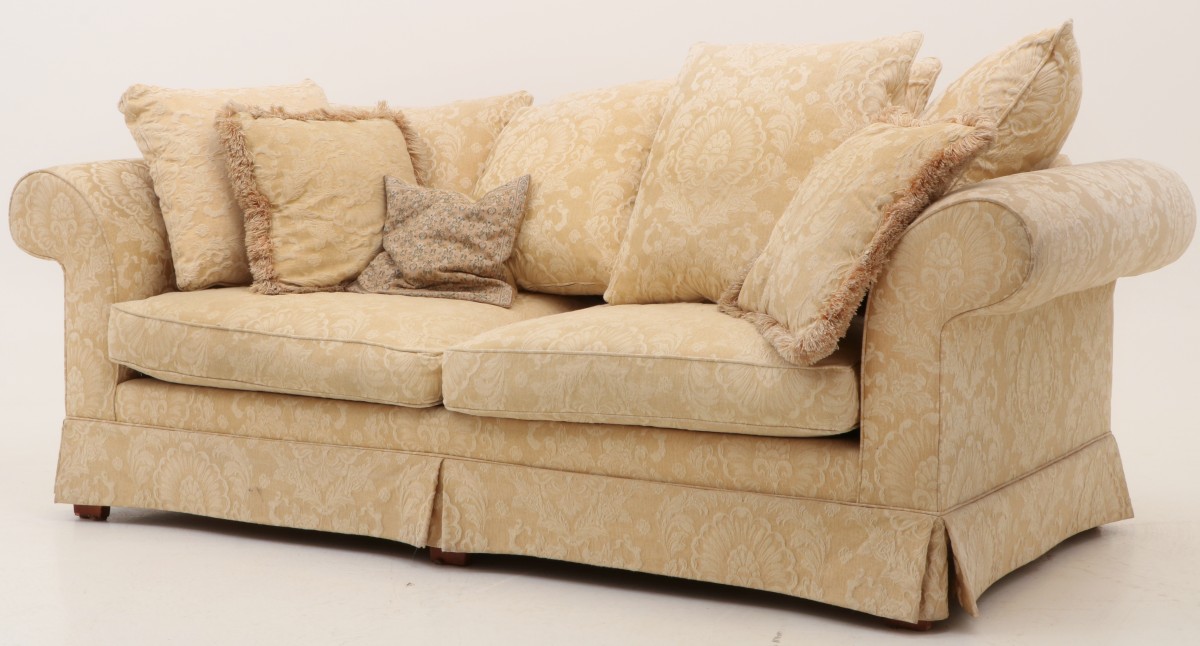 Een sofa met diepe zit en kussens.